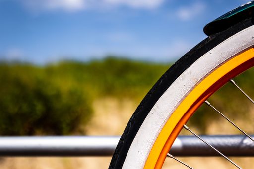 A closeup shot of a bicycle wheel on a blurred background