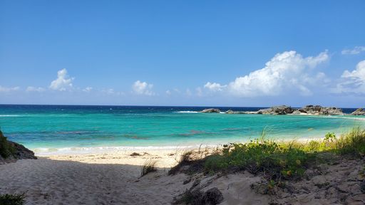 A beautiful view of the sea from the sandy shore with clear blue water