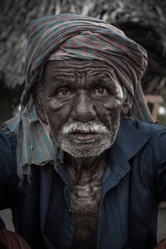 A vertical portrait of an old tribal man in details
