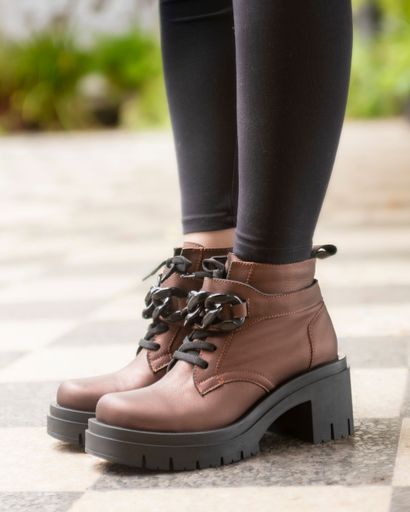The female legs wearing leather fashion shoes of different casual and dress styles in assorted colors