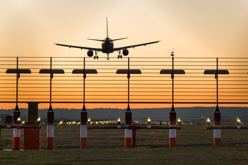 A photo of a landing plane at Stuttgart airport at sunset