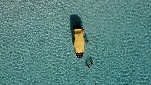 An aerial view of a boat and people at the beach of Cozumel in Mexico