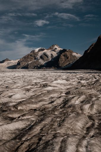 A vertical shot of the snowy rocky mountains under an evening sky in Fieschertal, Switzerland