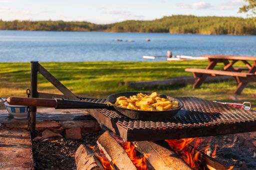 A closeup of cooking fried potatoes on firewood