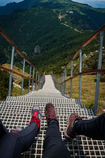 A vertical shot of couple's feet in Ceahlau National Park, Romania