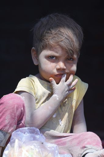 A vertical closeup of a poor little boy in Gotri, Vadodara, Gujarat, India.