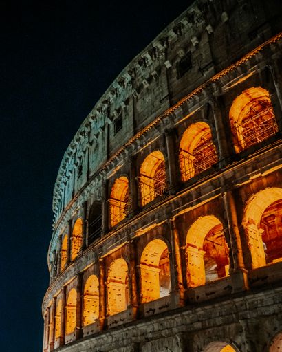 A vertical shot of the Colosseum in Rome, Italy at night