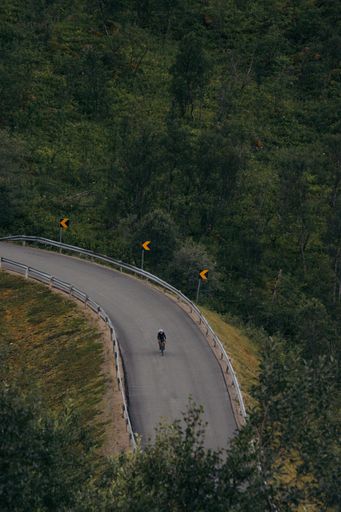 A vertical shot of a person riding a bicycle on the roads of Norway