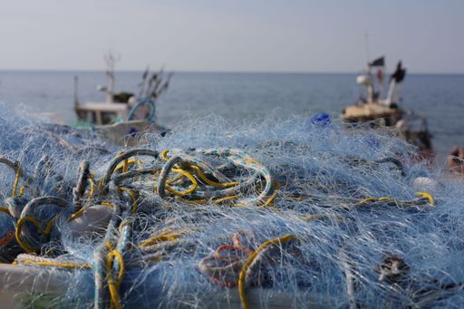 A closeup of blue fishing nets against the sea background