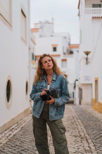 A vertical shot of a blonde, attractive woman on the streets of Lagos, Portugal