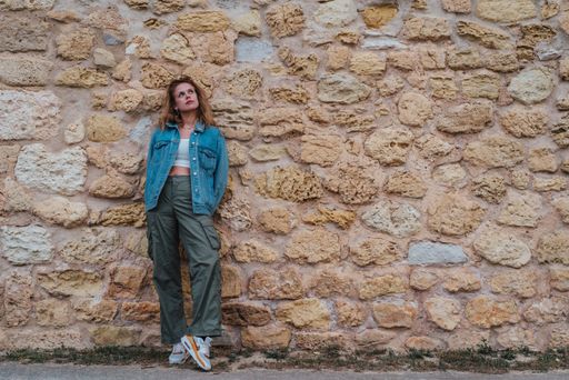 A young, attractive blonde woman leaning against a wall in Lagos, Portugal