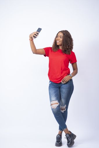 A beautiful black woman taking a selfie with her phone