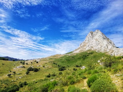 A peak of Gilbo in Riano, Spain with a blue cloudy sky above