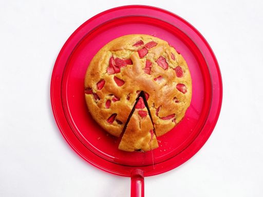 A strawberry cake on a red circle tray