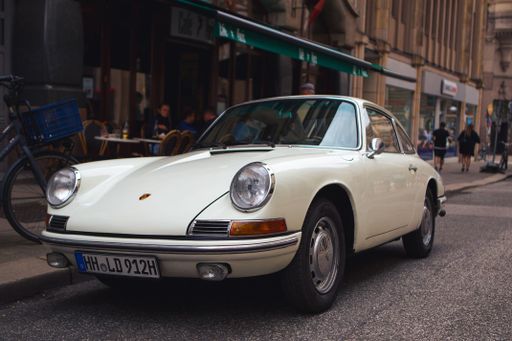 A closeup shot of a vintage Porsche 911 model parked on a street in Hamburg