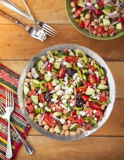 A vertical high angle shot of israeli salad with vegetables and cheese on a wooden table