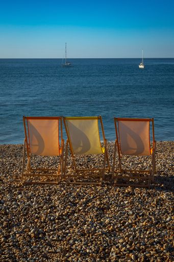 A vertical shot of sunbeds placed on a beach