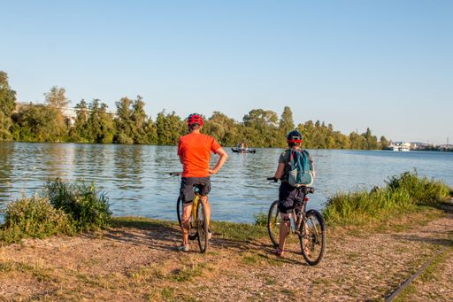 A closeup shot of two cyclists with bikes in front of a lake