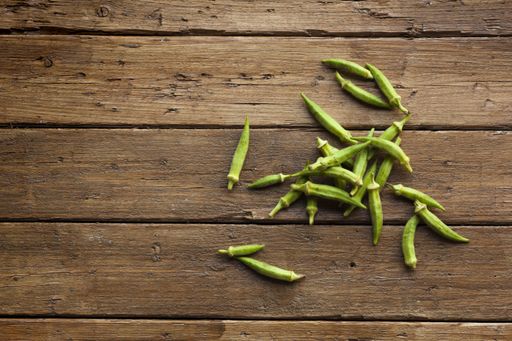 A high angle shot of green fresh okra on a wooden surface