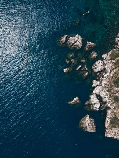 A rocky cliff overseeing the blue ocean on a sunny day