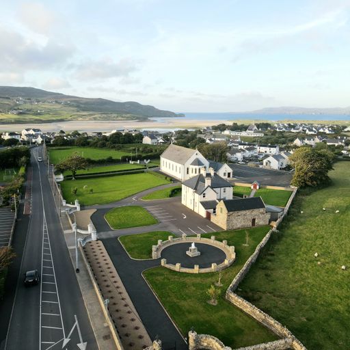 An aerial shot of houses near the street with hills in the background
