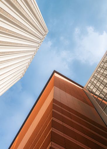 A low angle shot of high-rise buildings under a cloudy sky