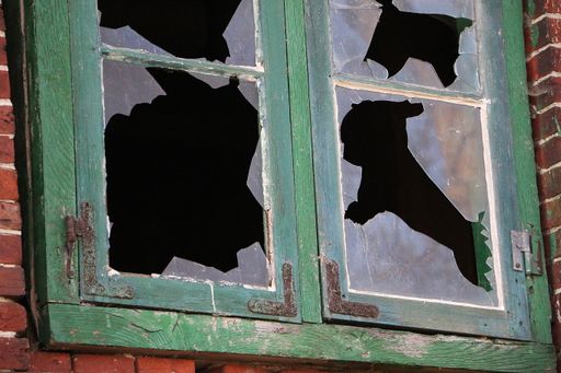 A close up shot of an old broken window