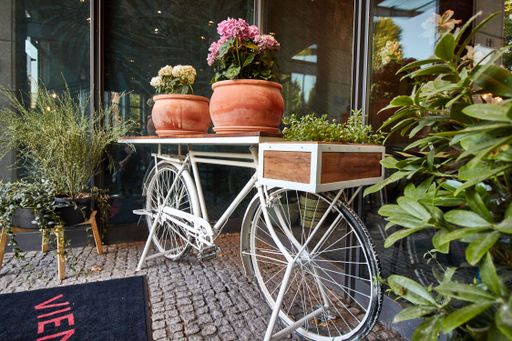 White bike with flowers in front of a store