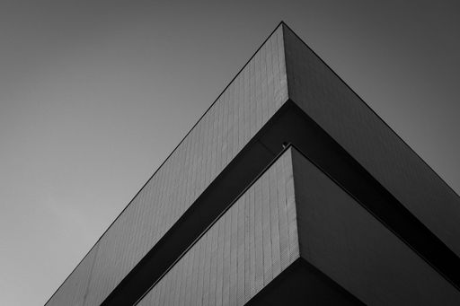A low-angle shot of the University campus in Poznan in grayscale