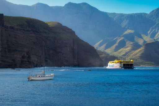 A boat sailing between Gran Canaria and Tenerife with hills in the background
