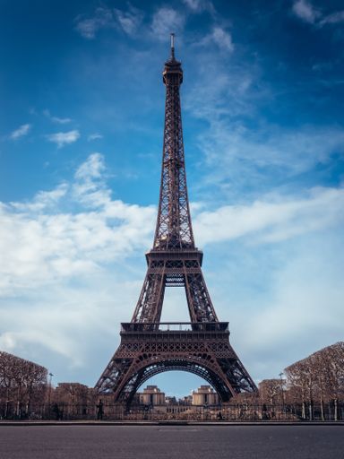 A beautiful vertical shot of the Eiffel Tower on a bright blue sky background
