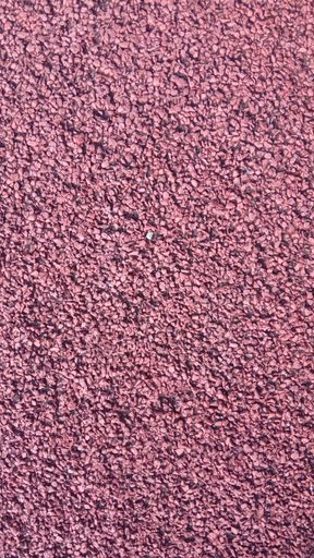 A vertical closeup of red pebbled ground - great for wallpapers or backgrounds