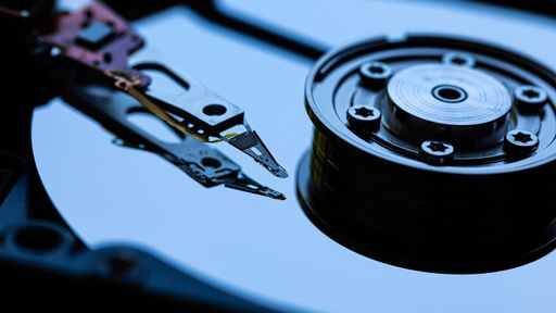 Macro Close up of inside of magnetic Hard Disc Drive with mirror surface and read writer head