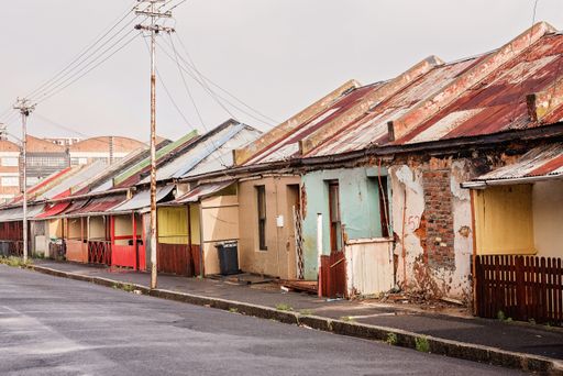 A view from the street with old houses falling apart on the pavement
