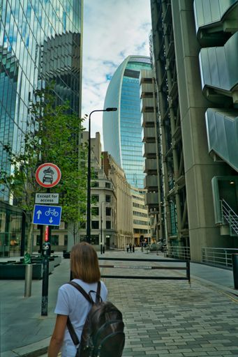 An adult person walking down the street with a large backpack on their back