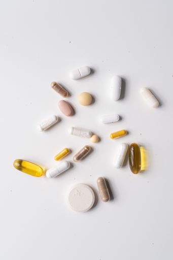 A vertical shot of different pills and capsules on a white surface
