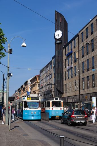 A vertical shot of trams and a large clock on a street of Gothenburg, Sweden