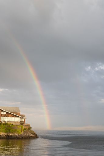 A vertical shot of a sunset sky rainbow over the sea at Swampscott