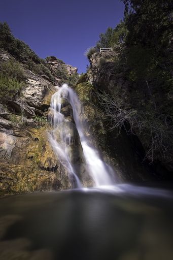 A vertical shot of a waterfall Amanaderos de Riodeva, Spain