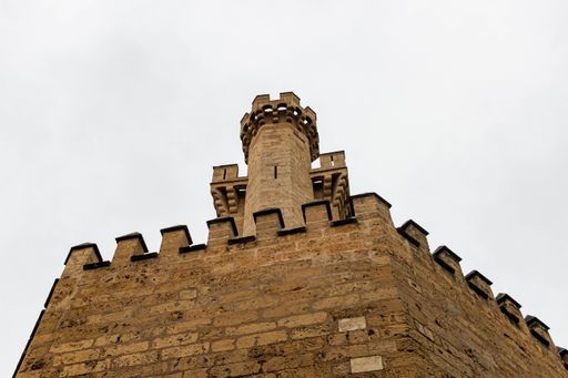 A low angle shot of a tower made of brick. The facade of the Palm Cathedral under the gloomy sky