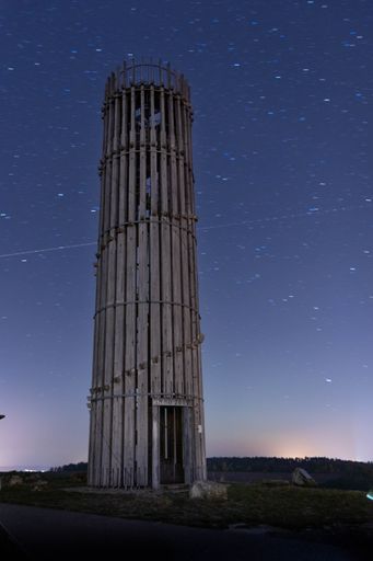 A vertical breathtaking view of Acacia lookout tower with star trails behind