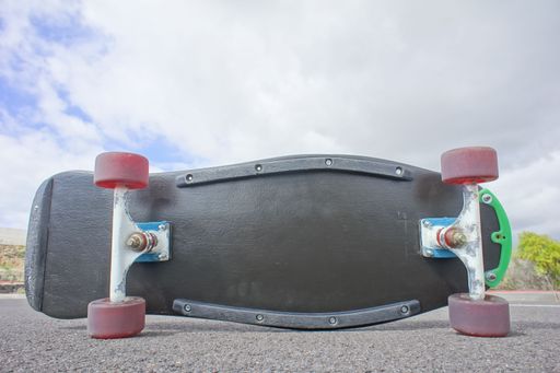 Vintage Style Longboard Black Skateboard on an Empty Asphalt Desert Road