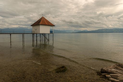 A Wooden jetty and boathouse on Lake Weissensee, Carinthia, Austria under cloudy sky