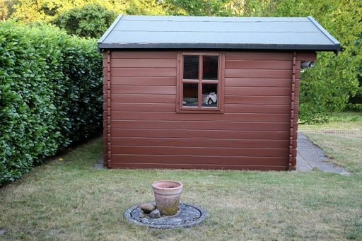 A small wooden storage house in the garden