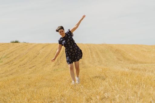 A beautiful shot of a female walking in the middle of yellow fields in Rio de Onor, Braganca, Portugal