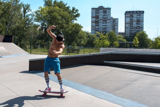 A skateboarder doing tricks on his skateboard during a sunny day