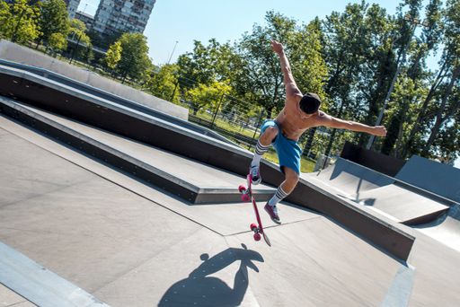 A skateboarder doing tricks on his skateboard during a sunny day