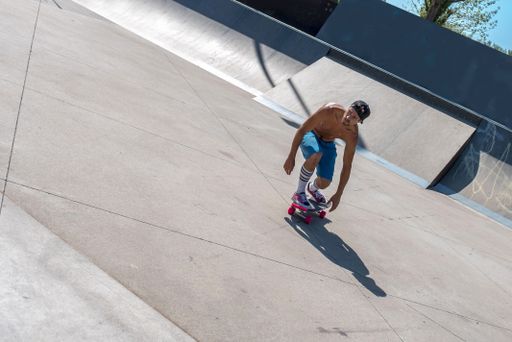 A skateboarder doing tricks on his skateboard during a sunny day