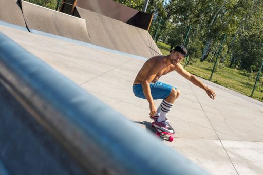 A selective focus shot of a skateboarder doing tricks on his skateboard during a sunny day