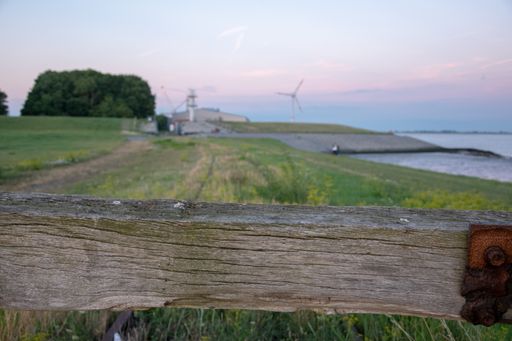 A selective focus closeup shot of a wooden fence on farmland near a beach